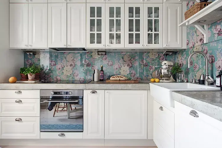 A modern Kitchen with Concrete slab having some kitchen related appliances, white cabinets and a sink fitted in the slab