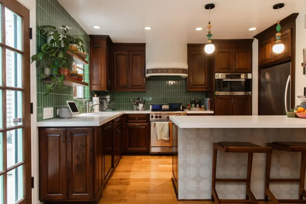 The deep walnut base cabinets with turquoise tiles backsplash and the countertop is made from stone 