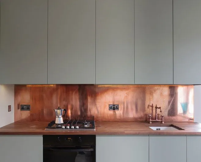 Kitchen with custom copper countertops that extend up the walls as a backsplash