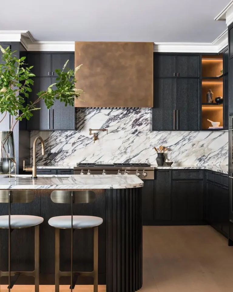 A beautiful kitchen with black cabinets and white backsplash with patterns