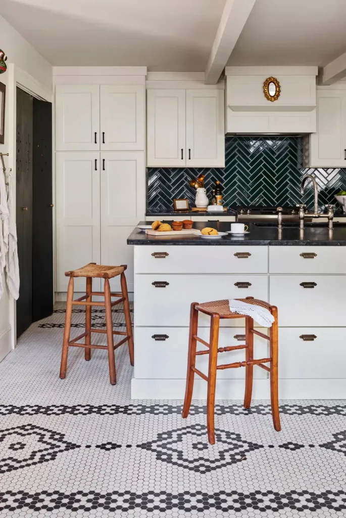 Glossy Herringbone Tiles Backsplash with matte greige cabinets and dark stone countertops 