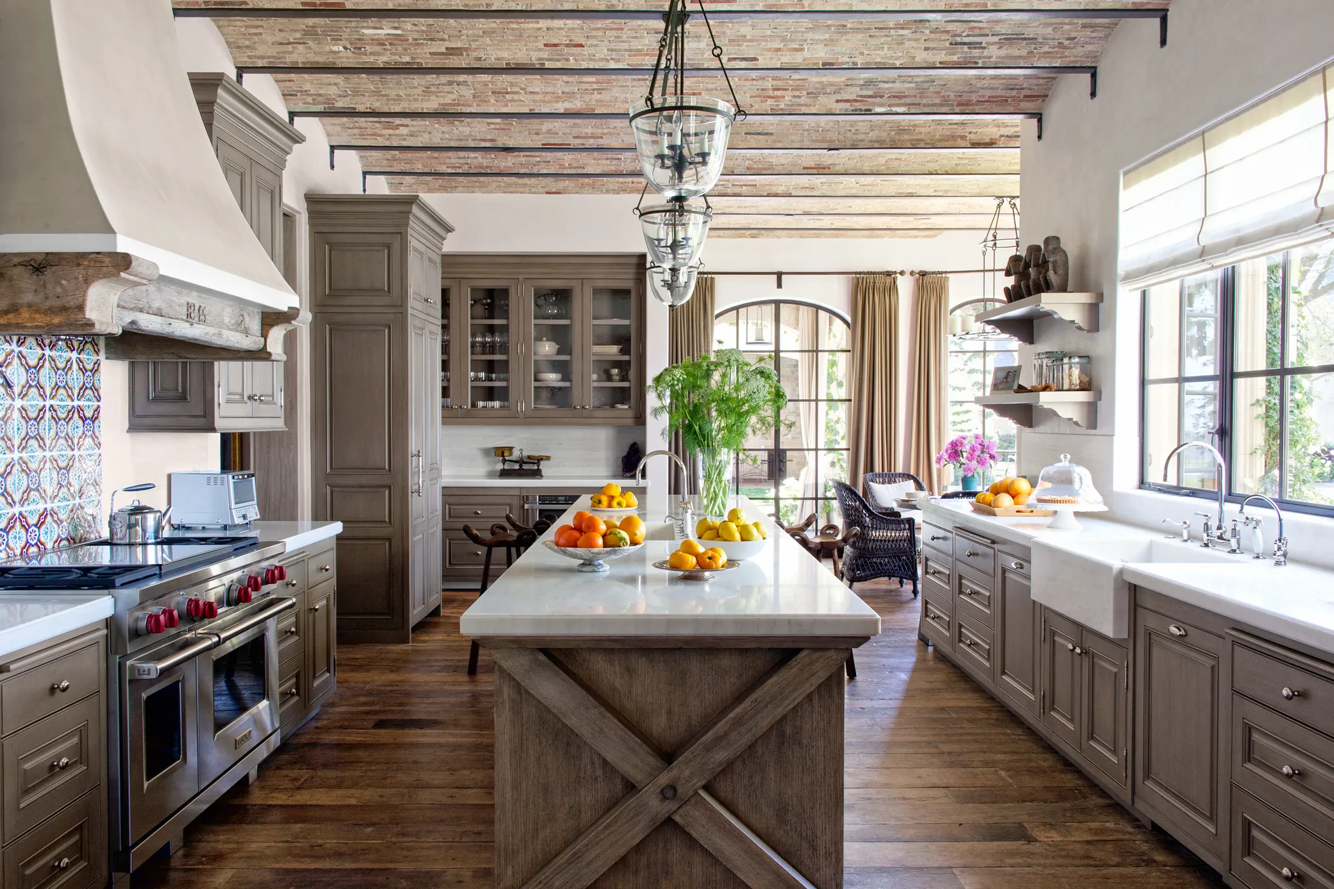 A modern kitchen with cabinetry finished in gold leaf and the island with an overlapping Corian table with gold inlay. 