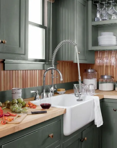 A beautiful kitchen with Hunter Green color on upper and lower cabinets and window trim. The countertop is made of butcher block  and fir beadboard backsplash 