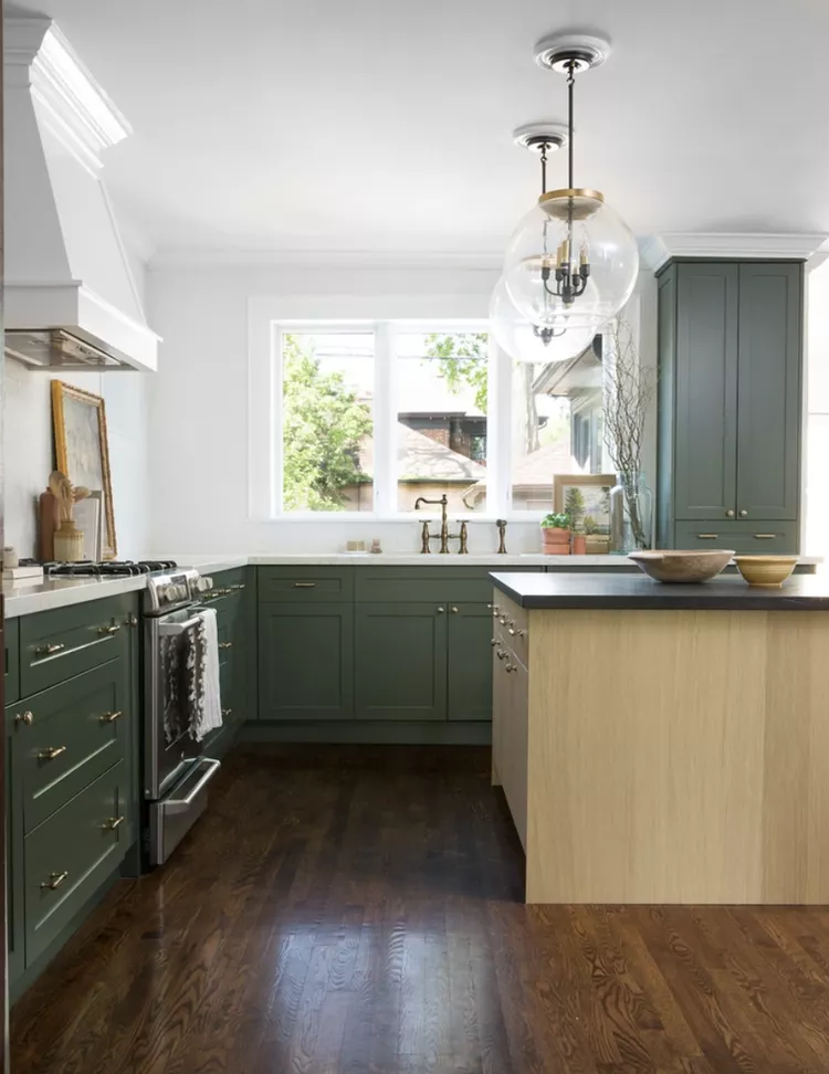 A beautiful kitchen with Kelly Green Cabinets and natural and white accessories 