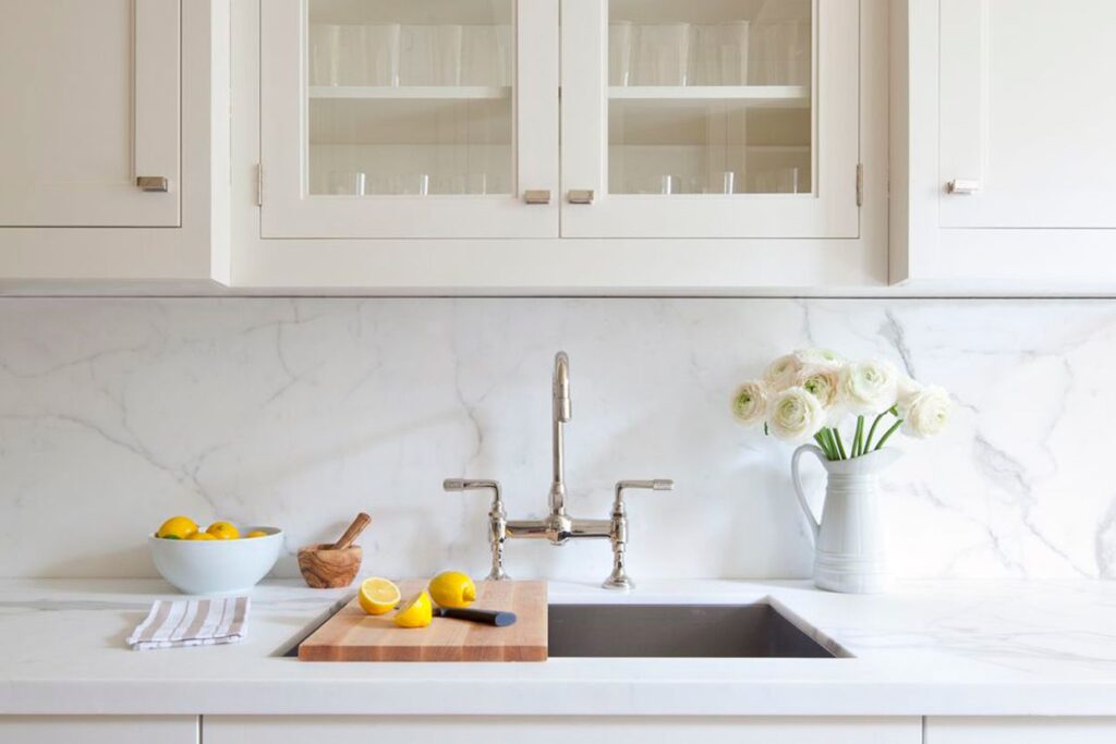 A beautiful kitchen with marble backsplash and countertop 