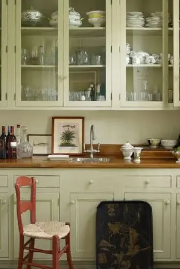 Beautiful kitchen with hardwood countertop and the glass front with sapling green painted cabinets