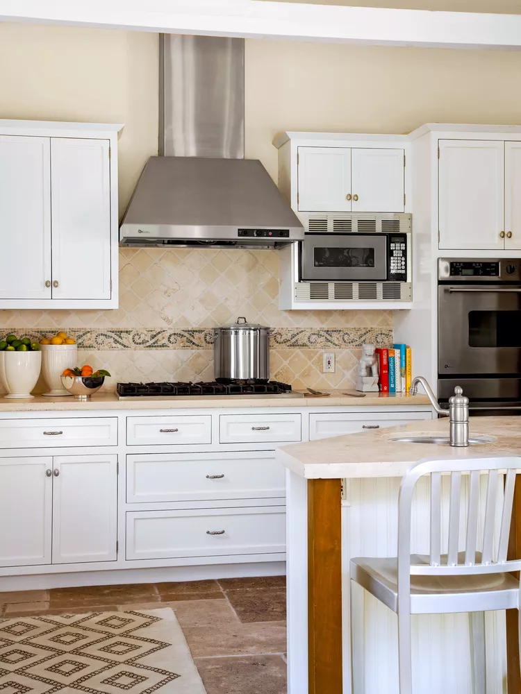 Tile Backsplash Accents  with off-white quilted travertine tiles with the warm white cabinetry and limestone countertops