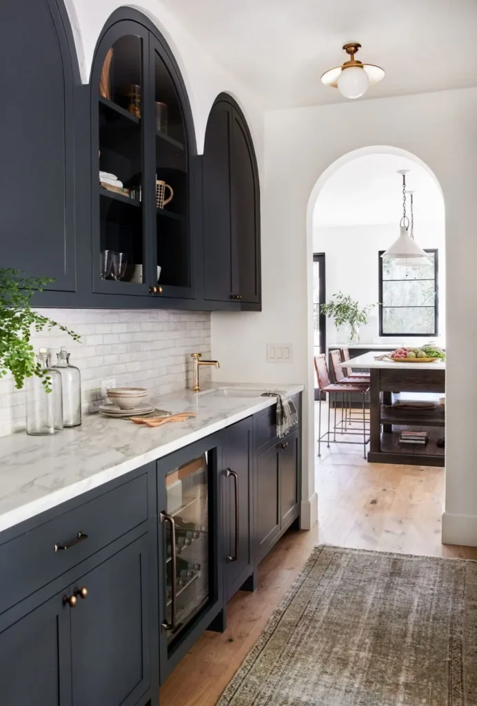 A classy kitchen with black arched upper cabinets 