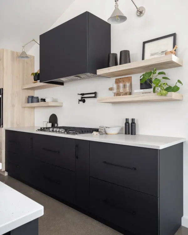 a beautiful kitchen with  matte black lower cabinets while shelves and wall cabinets are with a blonde stain