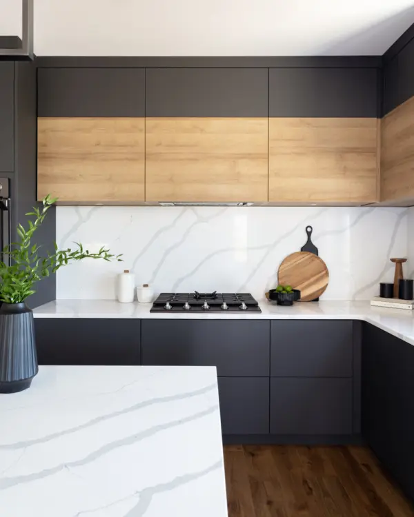 a modern kitchen with combination of cabinets with black cabinet doors and the upper cabinets with broad grain wood.