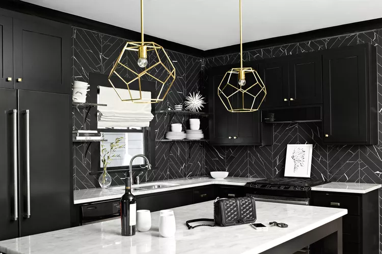 modern kitchen with marble herringbone tile and jet-black Shaker cabinets and to give metallic accents, brass light fittings and chrome cabinet knobs are used