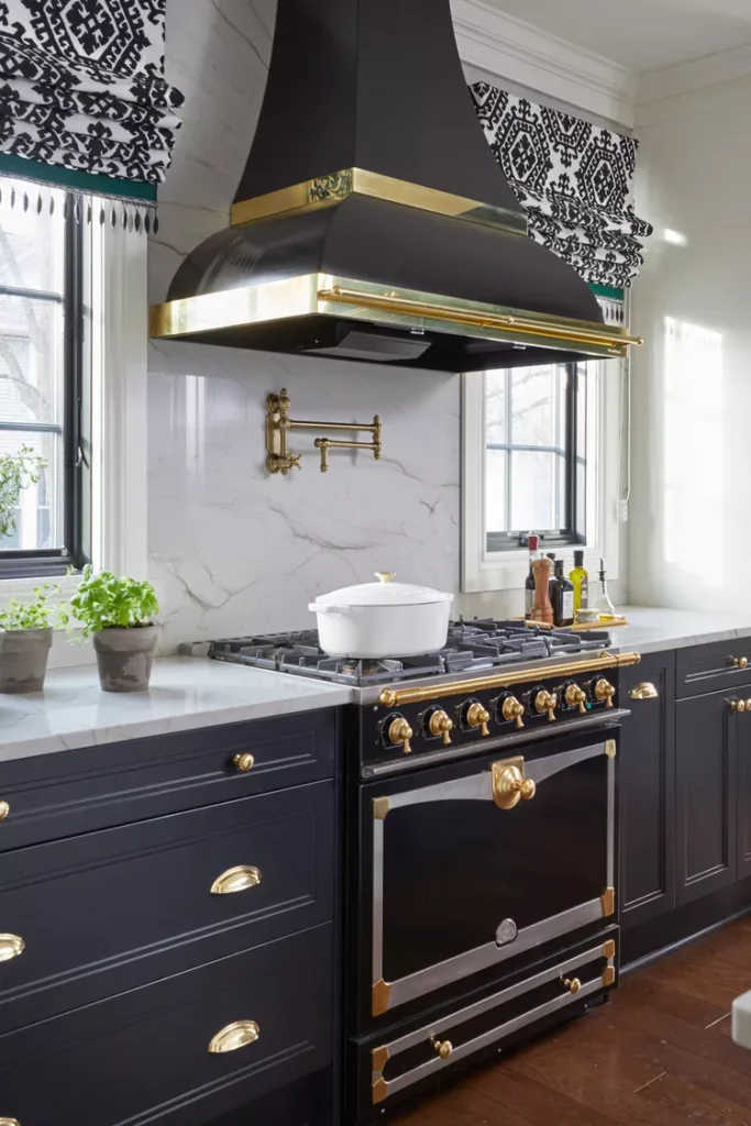 a modern kitchen with black cabinets and white countertop and backsplash